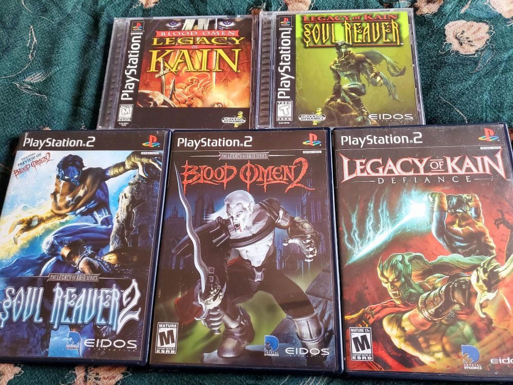 All five Legacy of Kain games for PlayStation and PlayStation 2, spread out side-by-side atop a dark green cloth.