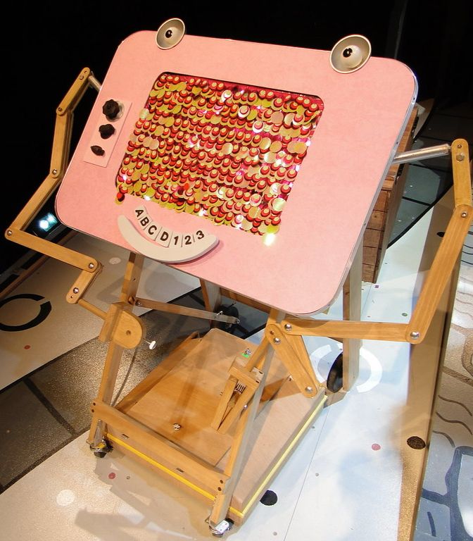 Magic Screen from Peewee, a sort of drafting table and tv. Glitter center, pink body, eyes and smile stretched out at top and bottom. 