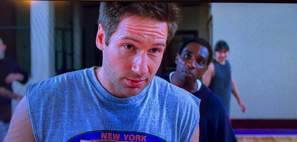 Mulder looking at Scully while holding basketball.