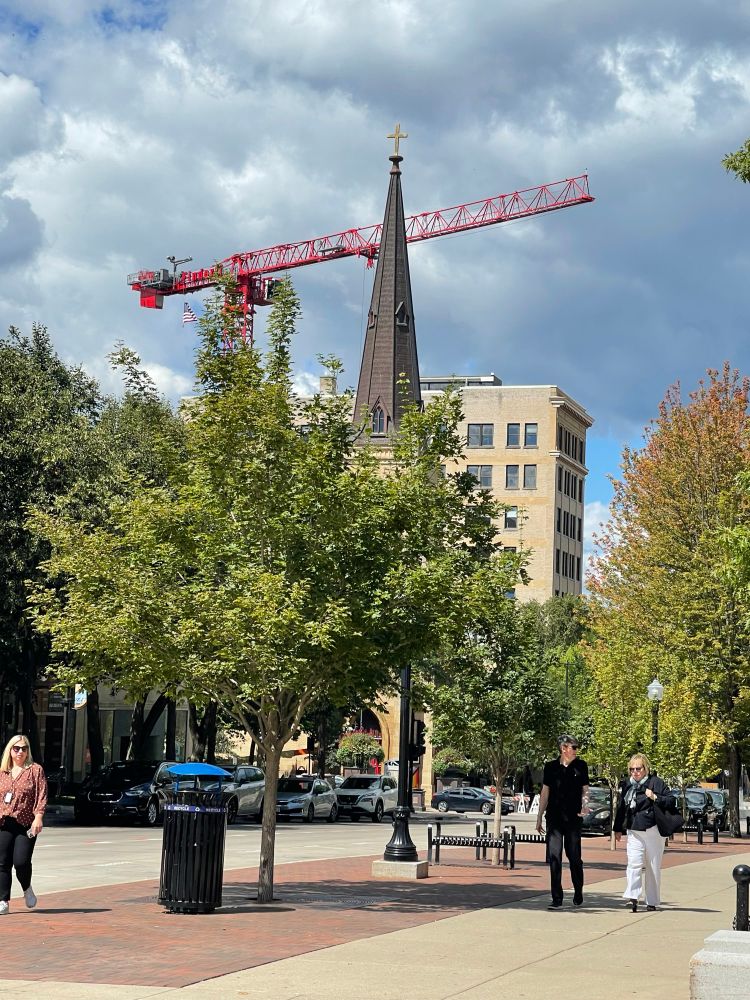 Construction crane looming over the spire of a church 