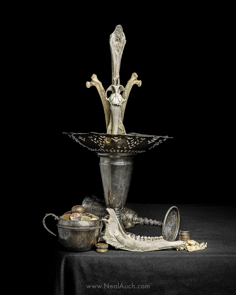 A vanitas still life. Bones are placed in a flower base as if to simulate a bouquet. Coins and more bones litter the table below. Art by Neal Auch.