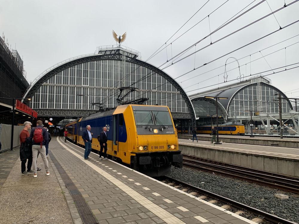NS TRAXX locomotive with yellow blue carriages at track 2b in Amsterdam Centraal.