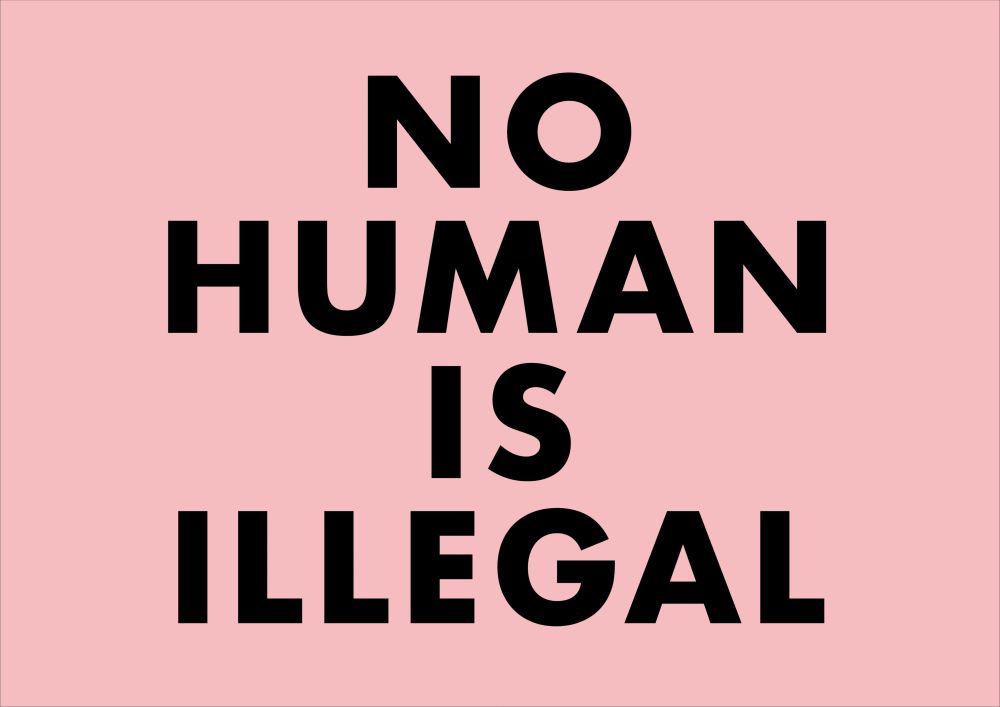 宮越里子さんのプラカード「NO HUMAN IS ILLEGAL」
ピンク地に黒の文字
