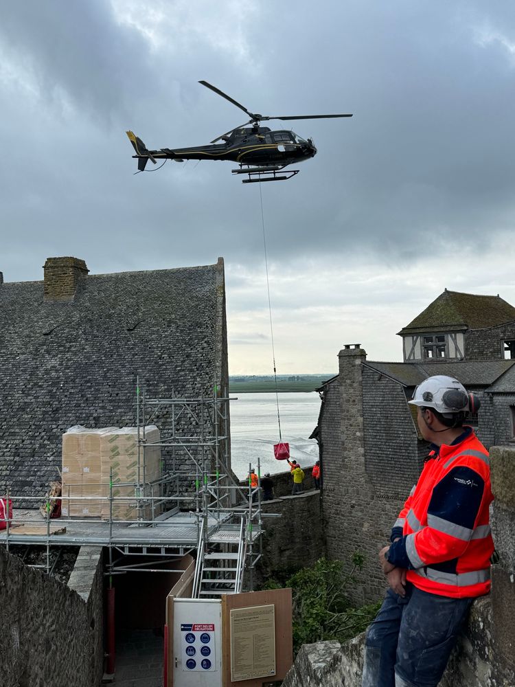 Helicopter delivering construction supplies at Mont-Saint-Michel