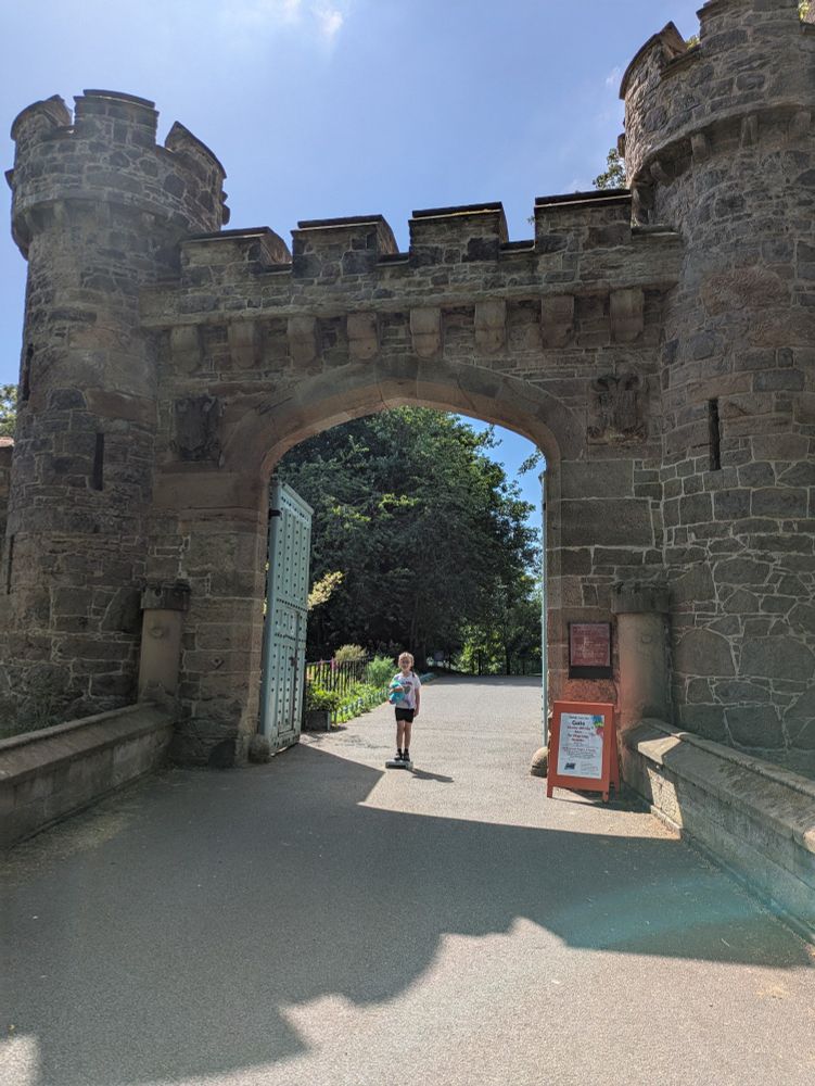 Child stood under stone arch