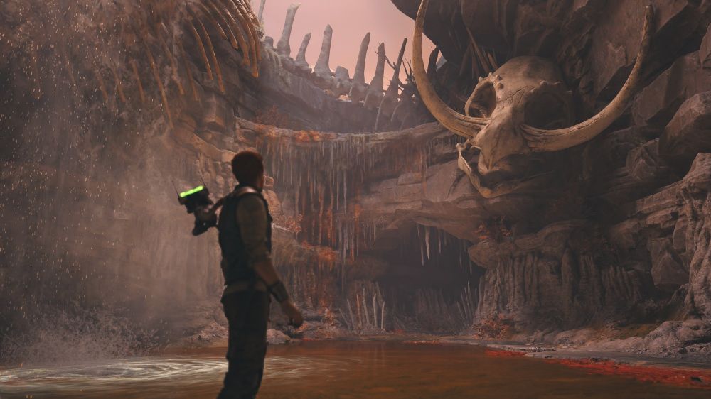 Screenshot of the game Star Ears Jedi Survivor, showing protagonist Cal Kestis in a cave looking at a giant monster skeleton
