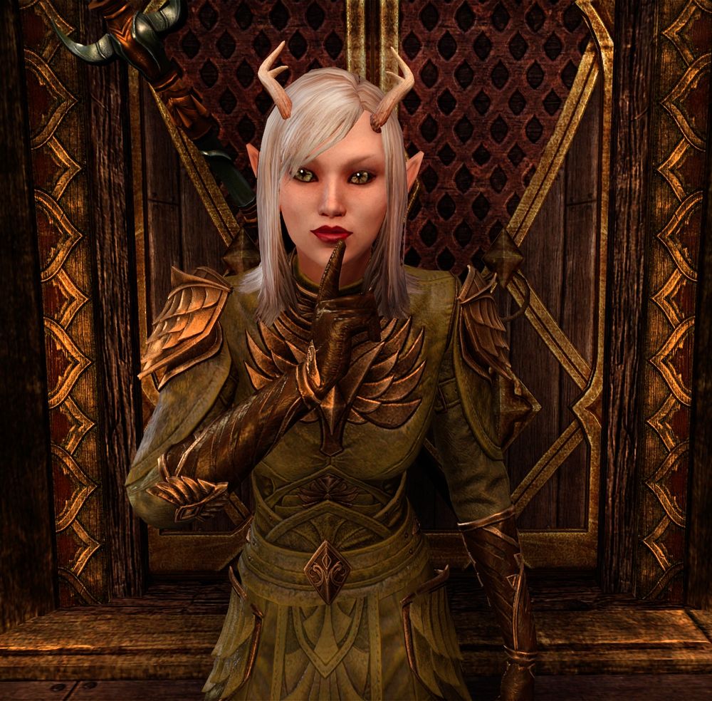 ESO screenshot of Dot in her usual green Ancestral High Elf armour. She holds her finger to her lips, like, "Shh."