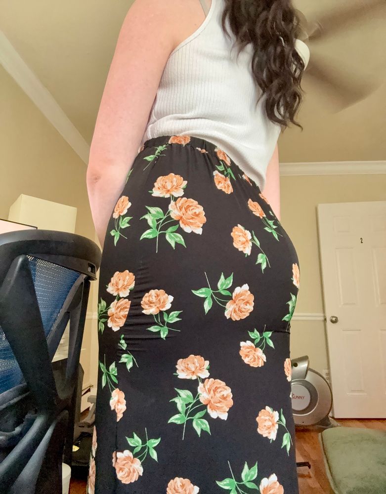 my ass in a black skirt with large rose patterns, pulled tightly against me