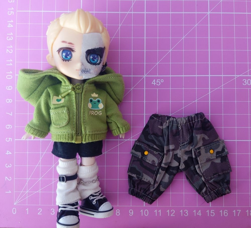 my darby doll next to the cargo pants that are too big for him.