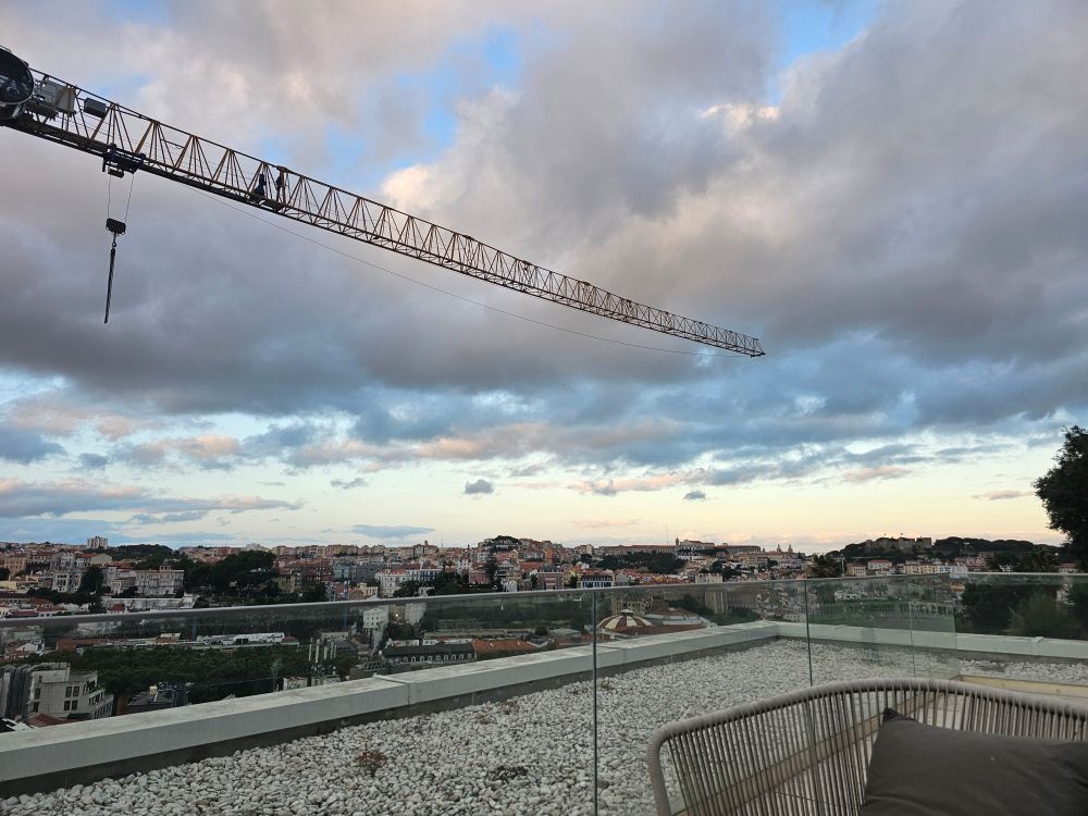 Part of a construction crane with Lisbon in the background 