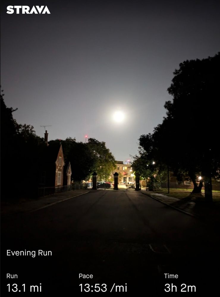A picture taken at night showing a very bright moon. Taken from inside a park. A Strava logo at the top left. The bottom reads: Evening Run. 13.1 miles. Pace: 13:53 per mile. Time: 3 hours 2 minutes.