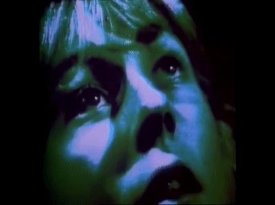 A gif from the opening credits of the 1981 BBC adaptation of The Day of the Triffids. Blue-lit, fearful faces staring upwards.