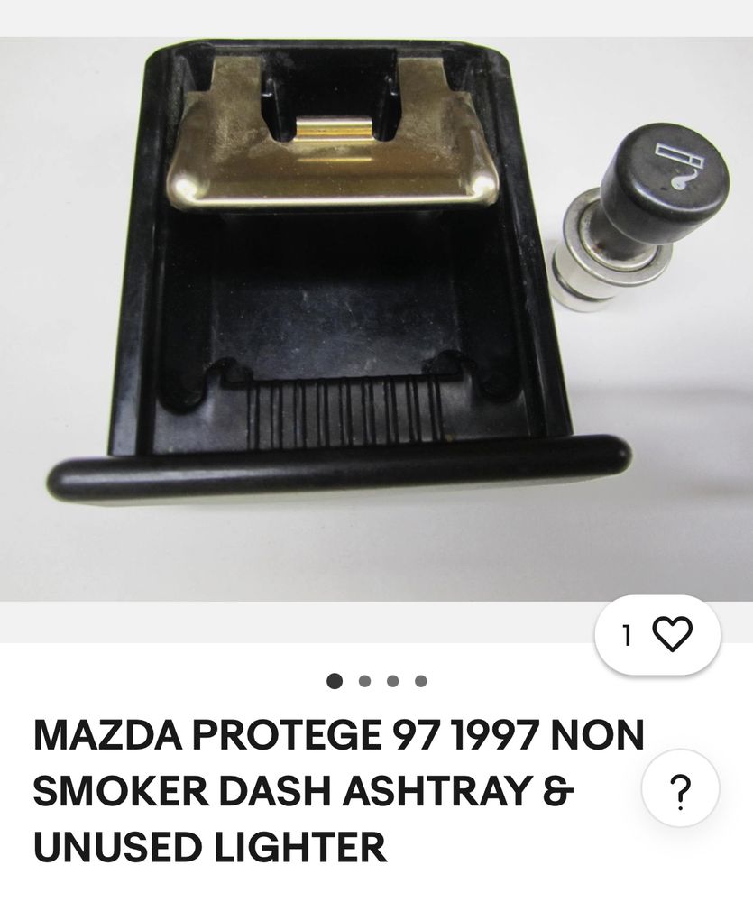 Screenshot of an eBay item: a wide ashtray drawer with a sort of hinge at the back and a round press-in coil lighter with an icon of a cigarette. The item title reads: “MAZDA PROTEGE 97 1997 NON SMOKER DASH ASHTRAY &
UNUSED LIGHTER.”