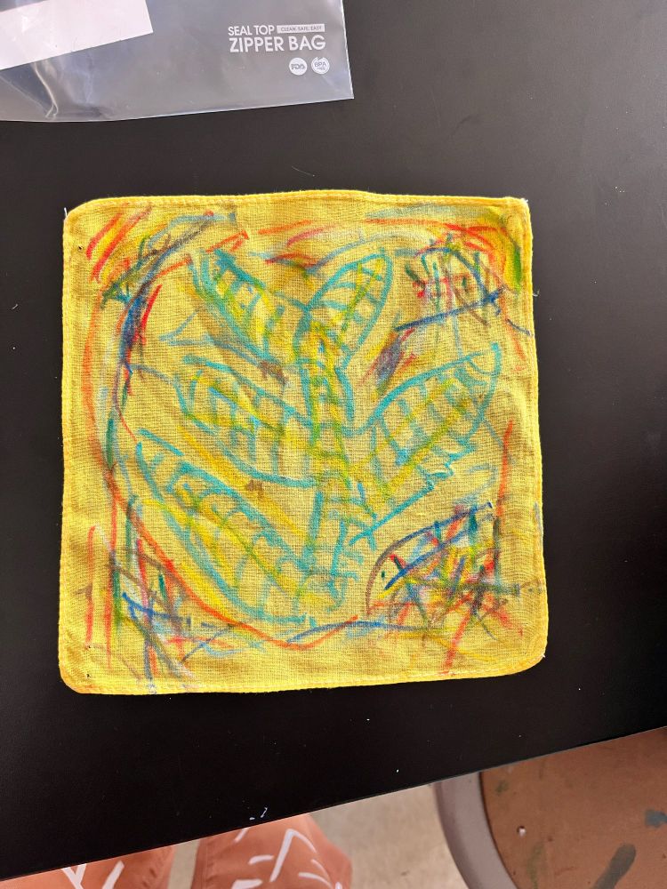 A child’s handkerchief featuring a leaf design and a colorful border 