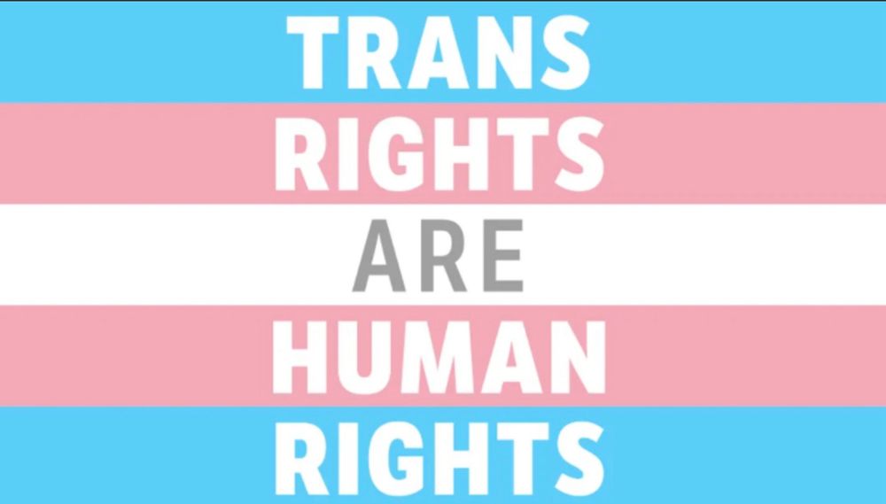 Trans Rights are Human Rights written on a blue pink and white Trans Pride Flag.