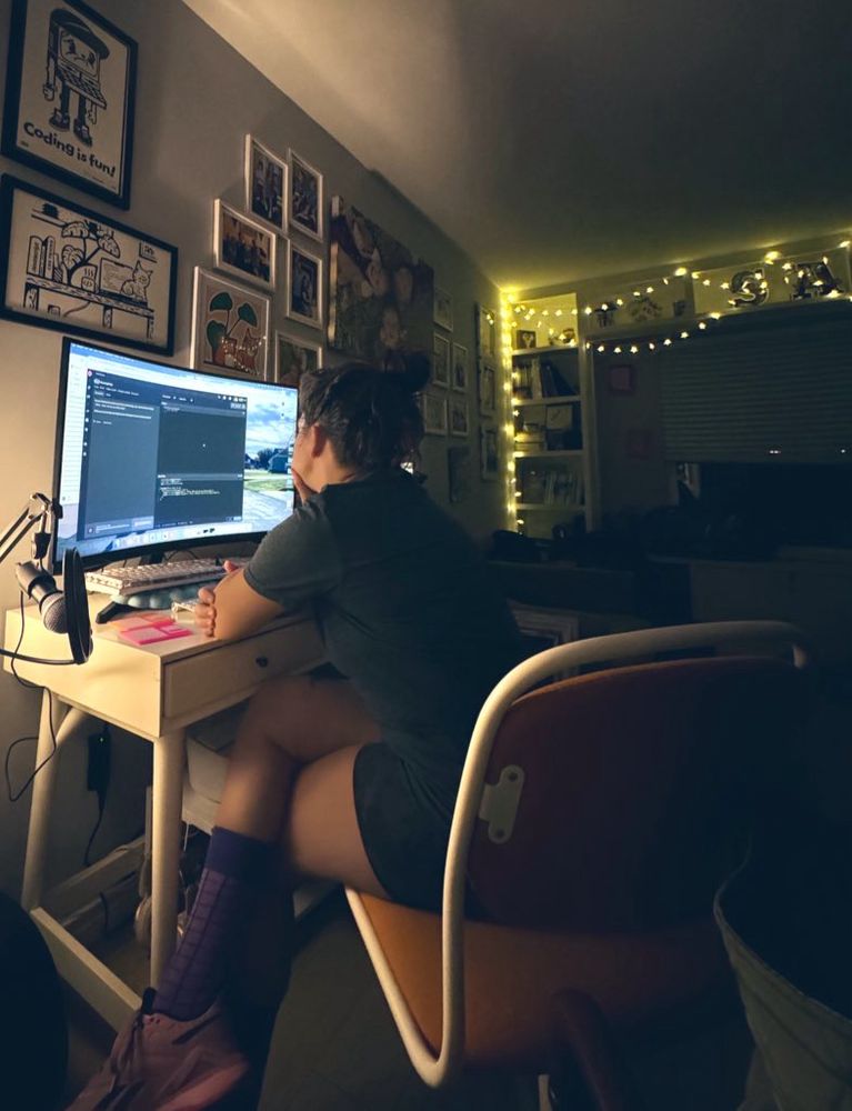 Woman sitting at computer in dark room 