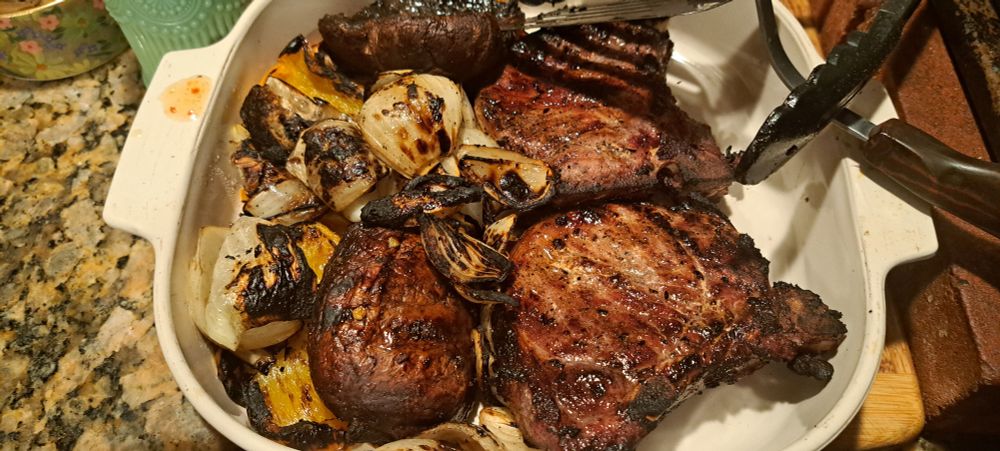 Porkchoos shown with grilled mushrooms, onions, and peppers.