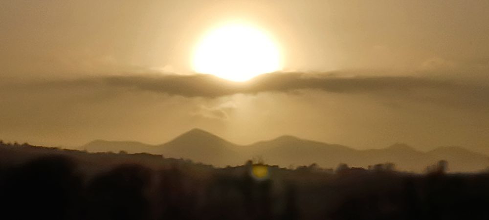 Sun dominates this picture 
Over the N side of the mountains