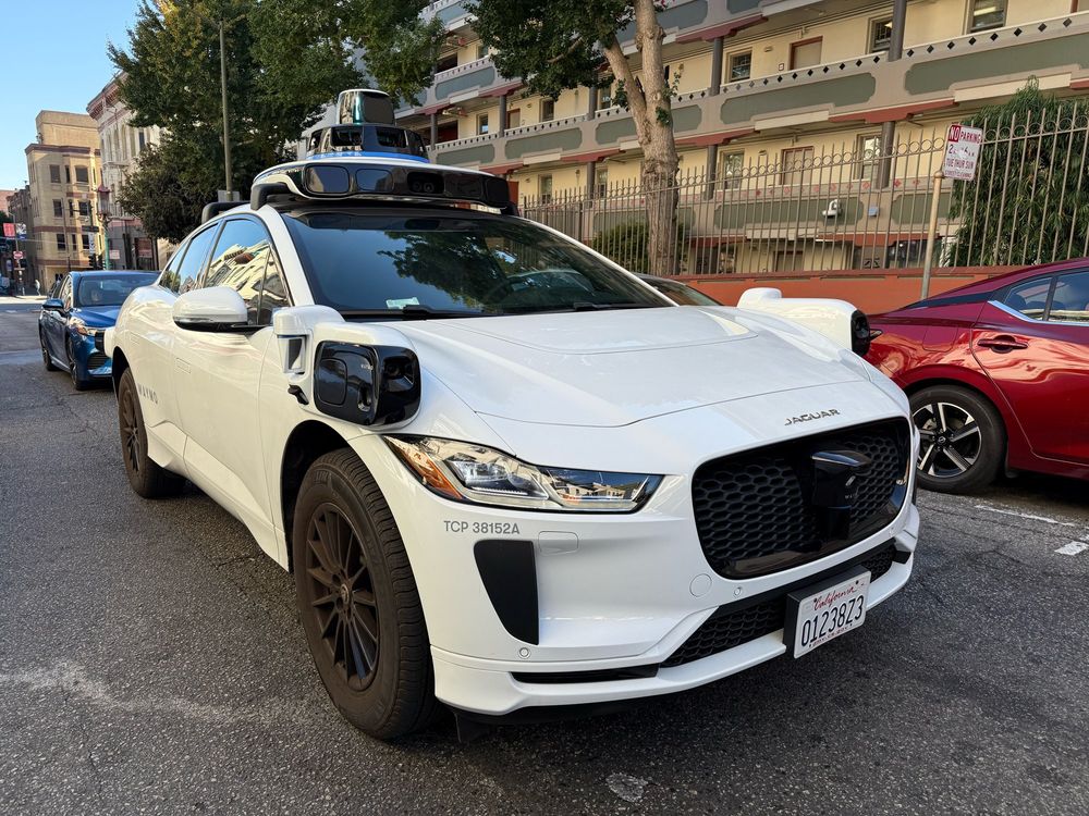 Photo of a Waymo vehicle from the front, during the day. 