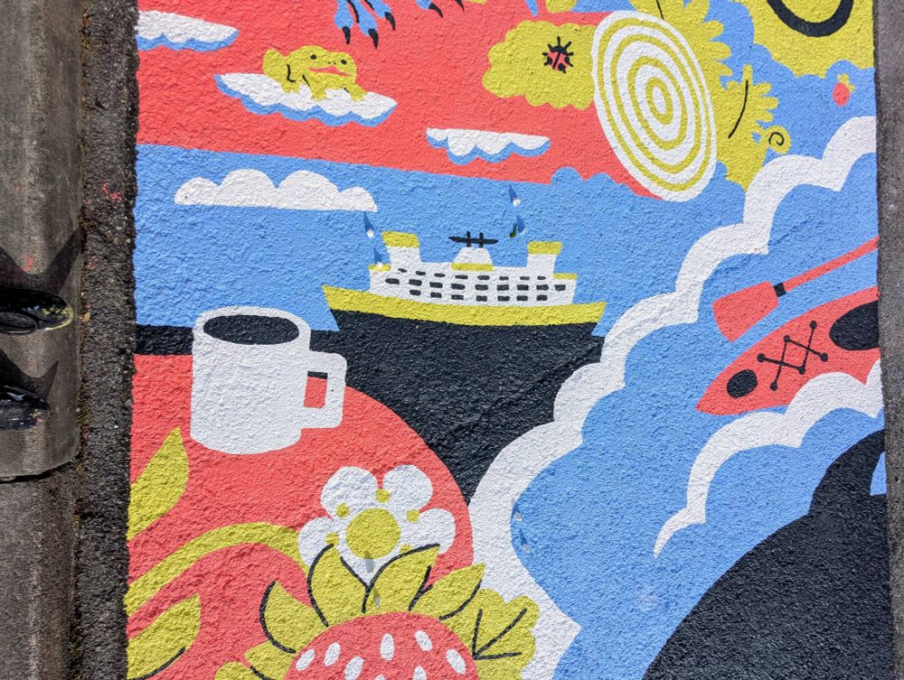closer shot of the mural showing a kayak, a coffee cup, and the ferry! 
