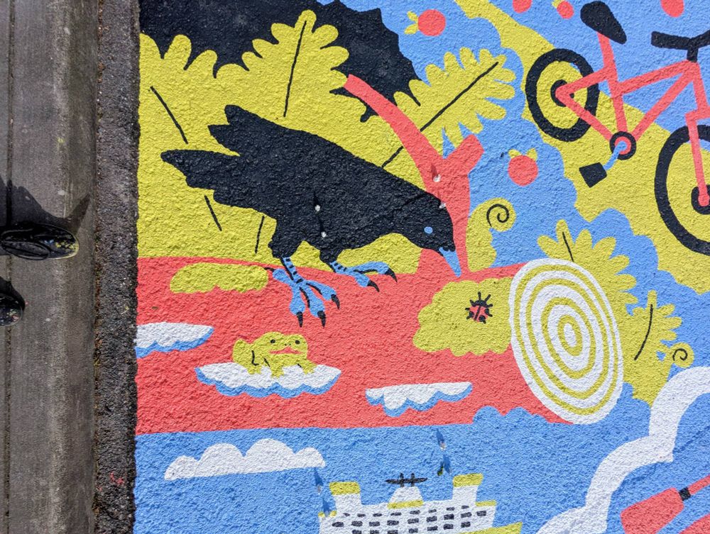 closer shot of the mural showing a crow on a log with a ladybug and a frog