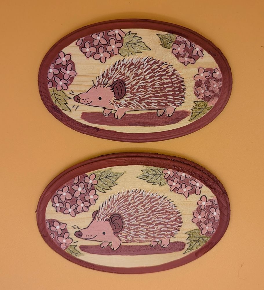 two hand painted hedgehog plaques