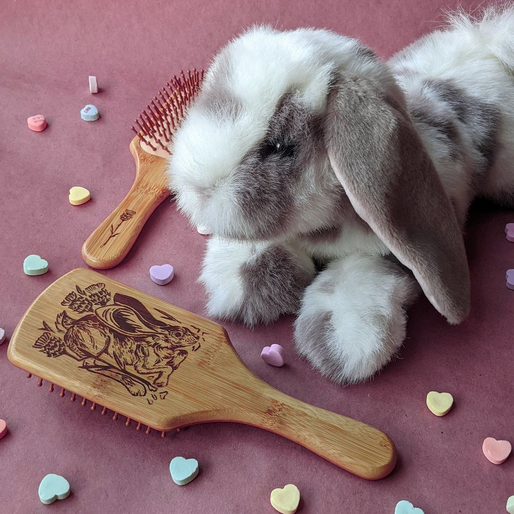 photograph of a bamboo harebrush with a hair design, posed by a stuffed bunny