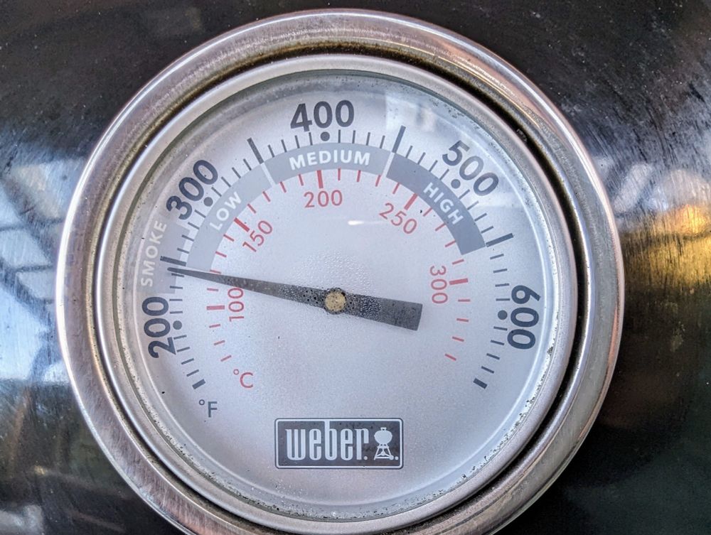 Das Deckelthermometer eines Kugelgrills ist zu sehen