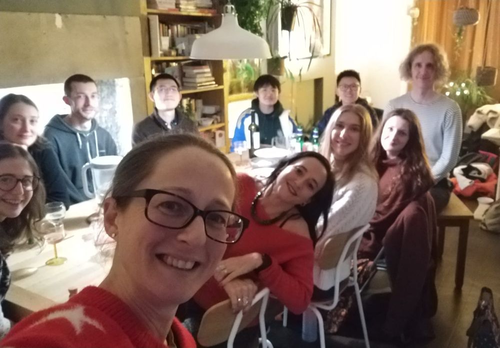 A selfie of 11 people around a table at our Christmas dinner. Claire is taking the picture and is in the foreground. Background shows Simona and members of Lancaster Phonetics Lab.