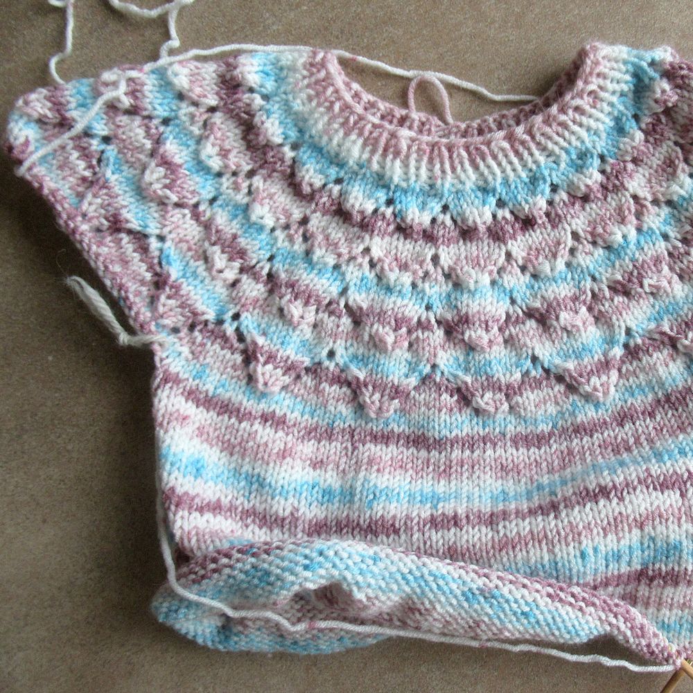 Start of a hand knitted pullover with lace yoke, knitted top down and in the round.