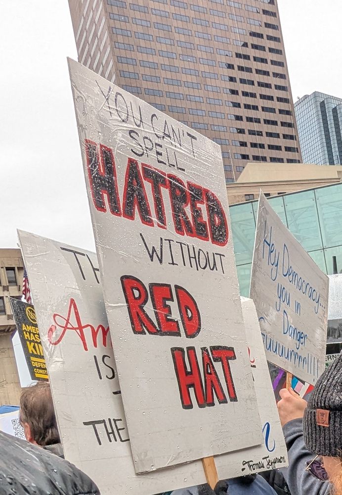 Sign says "you can't spell hatred without red hat"
