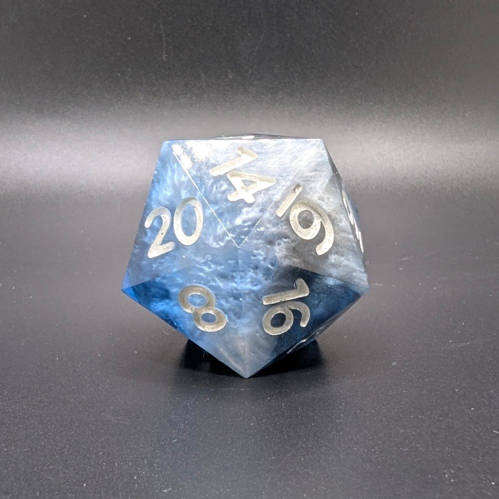 Riptide. A 30mm d20 sharp edge dnd chonk. The colors are a sapphire blue, a snowy white, and a black all swirled together. It looks like the ocean. The lighter waters near the beach, fading out into the blue of the water then the deeper black of the depth of the ocean. Careful you don't get swept away by the Riptide. 