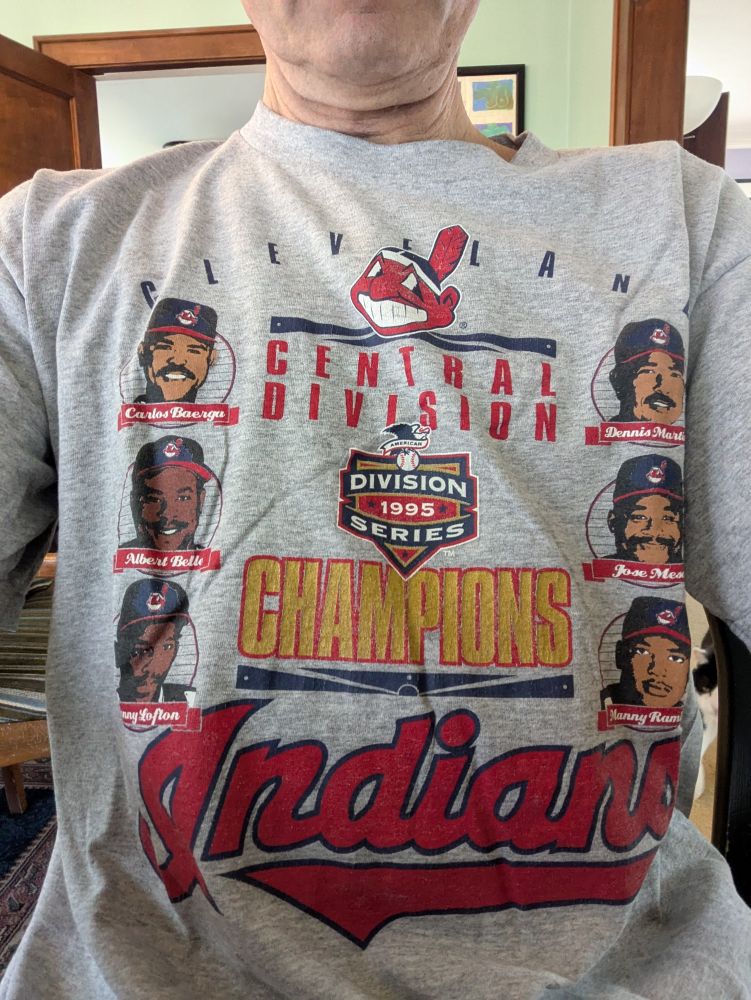 A grey t-shirt celebrating the 1995 Cleveland baseball team, featuring illustrations of Carlos Baerga, Albert Belle, Kenny Lofton, Dennis Martinez, Jose Mesa, and Manny Ramirez. Sorry about the chief!