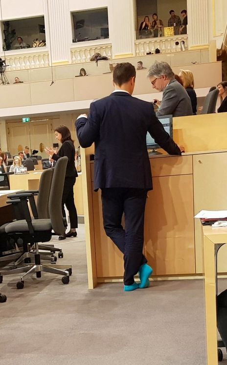 Der österreichische Finanzminister Gernot Blümel steht im Mai 2019 barfuß in türkisfarbenen Socken am Rednerpult des österreichischen Parlaments. Umgeben von Abgeordneten und klassizistischer Architektur wirkt die Szene zugleich formell und irritierend leger. Türkis ist die Farbe "des neuen Stils" seiner Partei.
