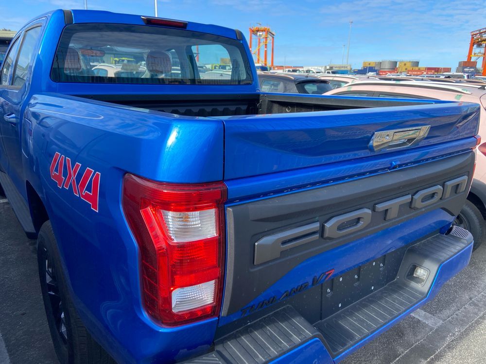 A blue pickup truck from the back with the name Foron written in large block letters along the tailgate.