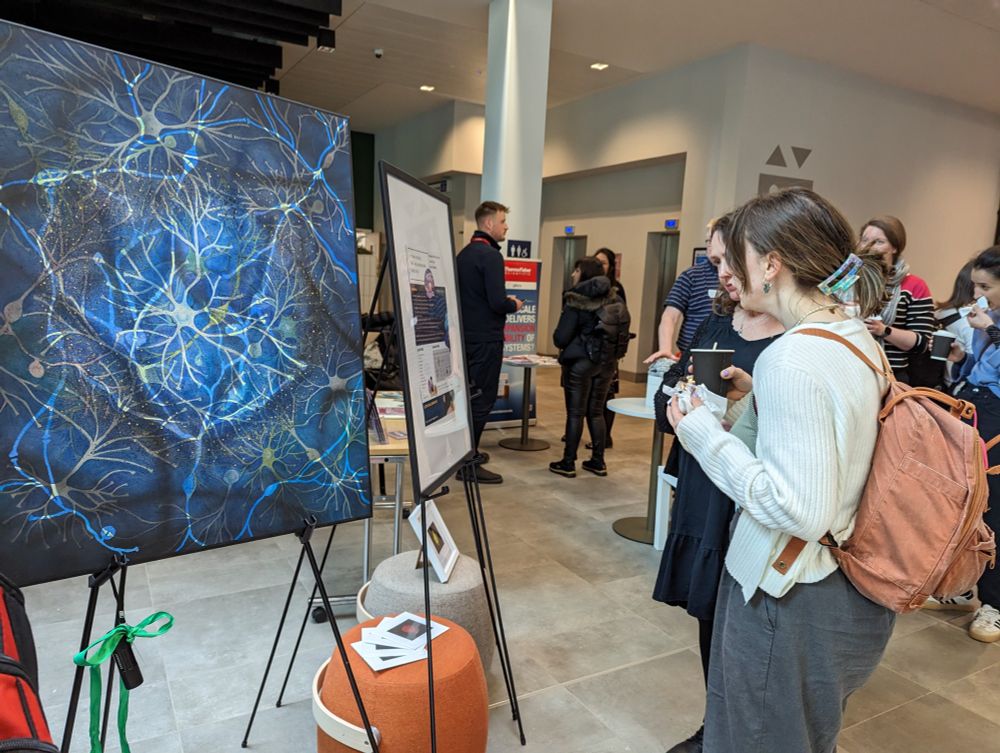 Photo of people looking at an artwork on display