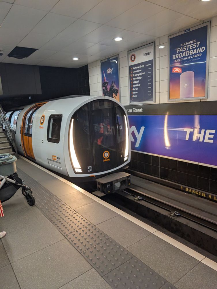 Glasgow Subway train arriving at a station platform.