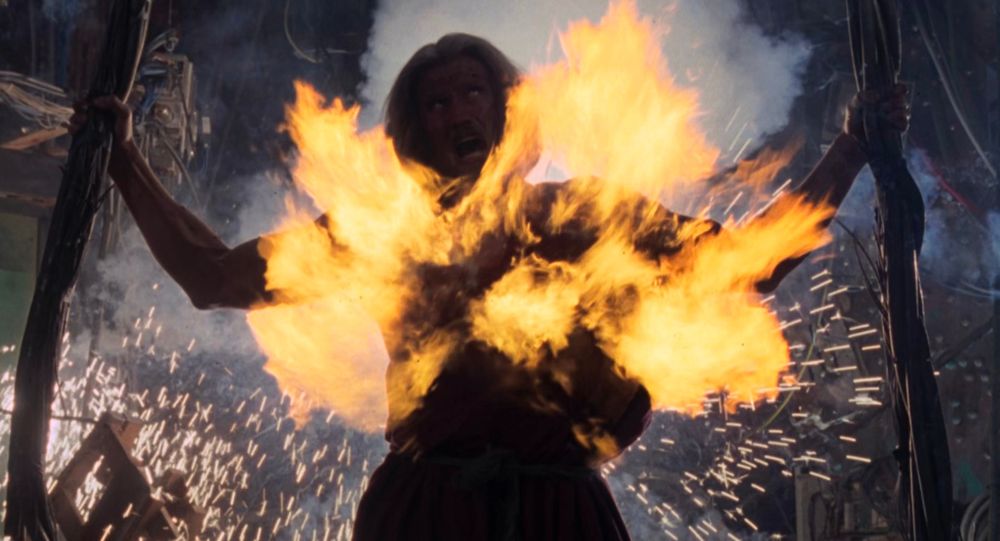 The guy is on fire and being electrocuted with his arms outstretched.
