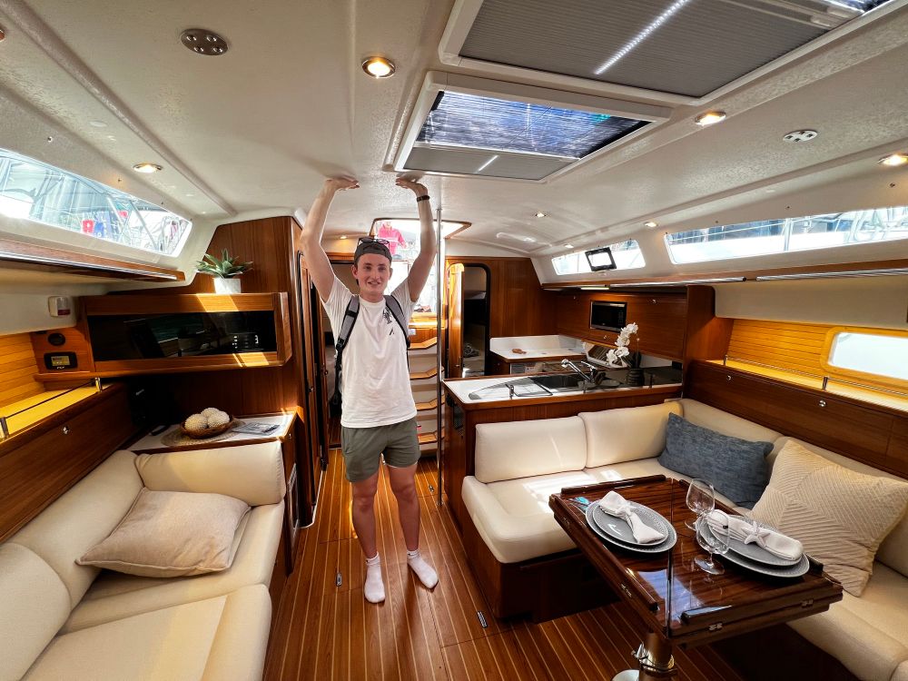 Me standing in the main salon of a 42 ft. Sailboat marveling At how big it is.