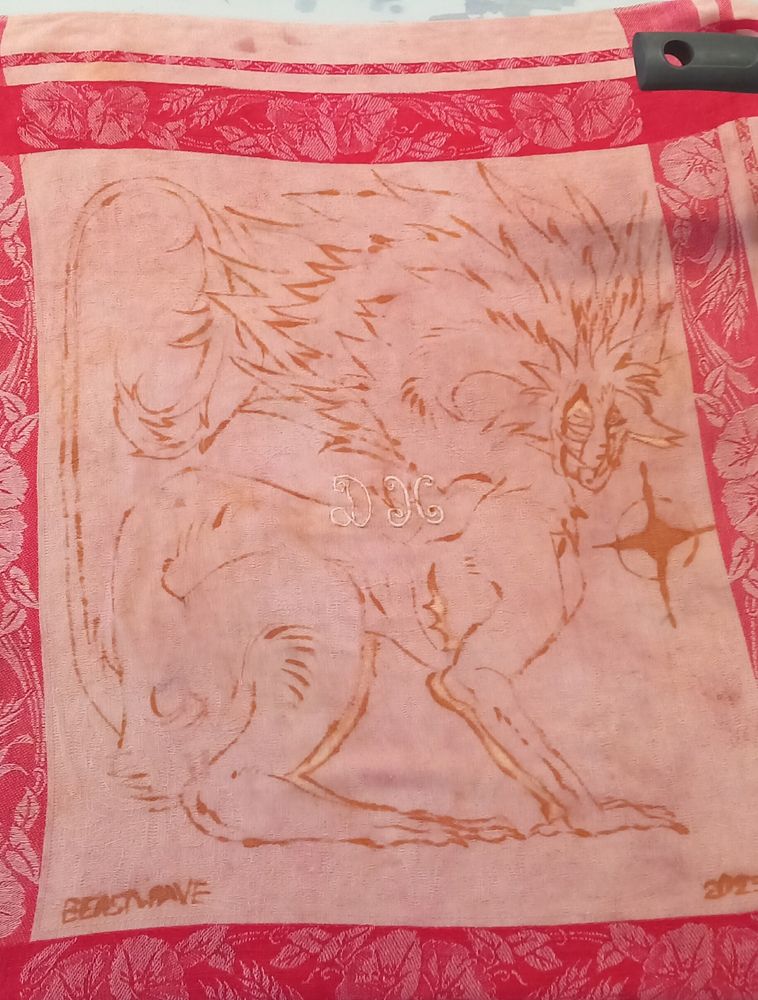 "HATEFUL", a tea towel tint with madder roots that features a horned dragon looking intensively, showing teeth with a star on the right side. This piece represents the embodiment of strength and bravery about being transgender.