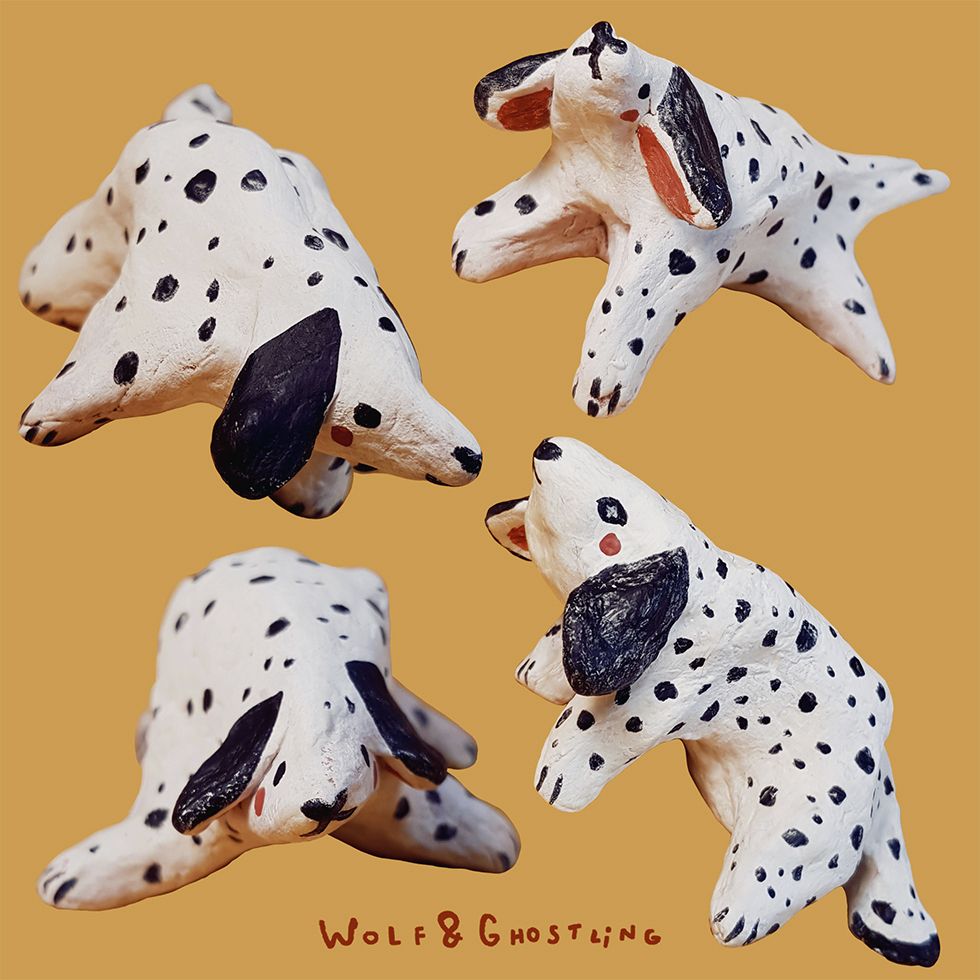 four small sculptures of dalmatian dogs on a bright yellow background