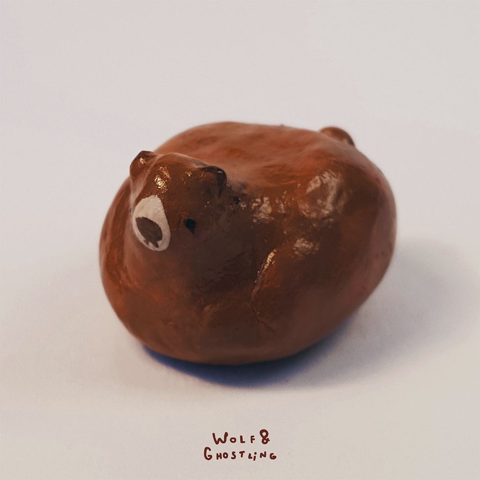 a very small, bean shaped brown bear sculpture with a cute little face