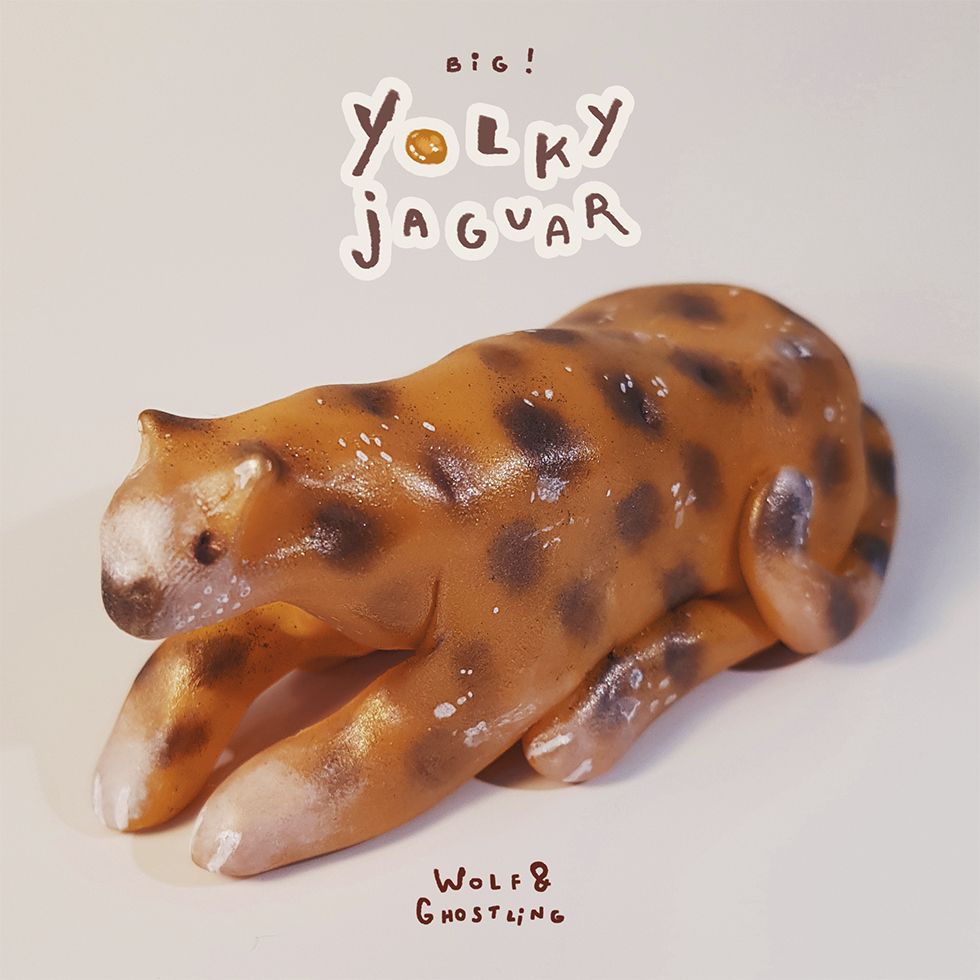 photos of a small, shiny, yolk yellow jaguar sculpture