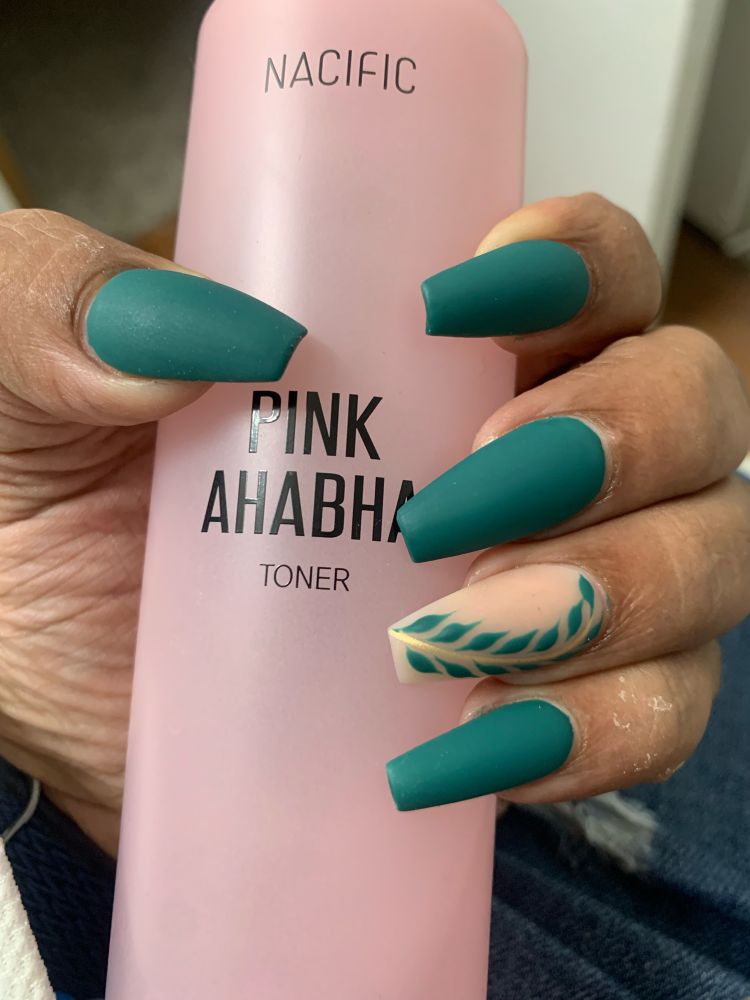 green matte nails on my thumb, pointer, middle and pinkie nails. my ring finger is a matte nude with a green fern design. the stem is a chrome gold. 