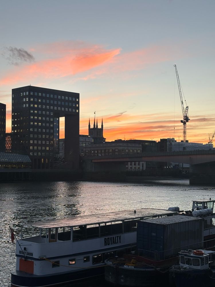 A pinky golden sunset across the River Thames, looking over towards Southwark Cathedral 