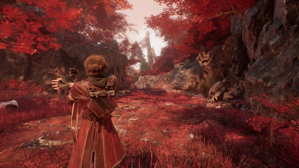 Gustave stretches his arm out, clad in red and surrounded on all sides by vermilion foliage.