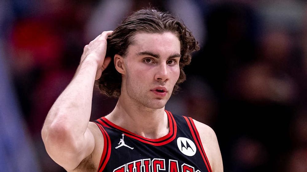 Josh Giddey of the Chicago Bulls brushing back his hair. 