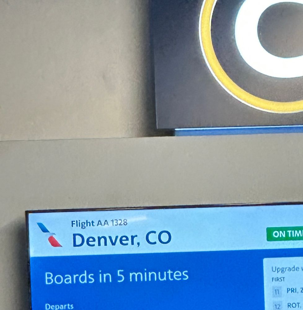Photo of gate screen at the airport showing a flight to Denver Colorado