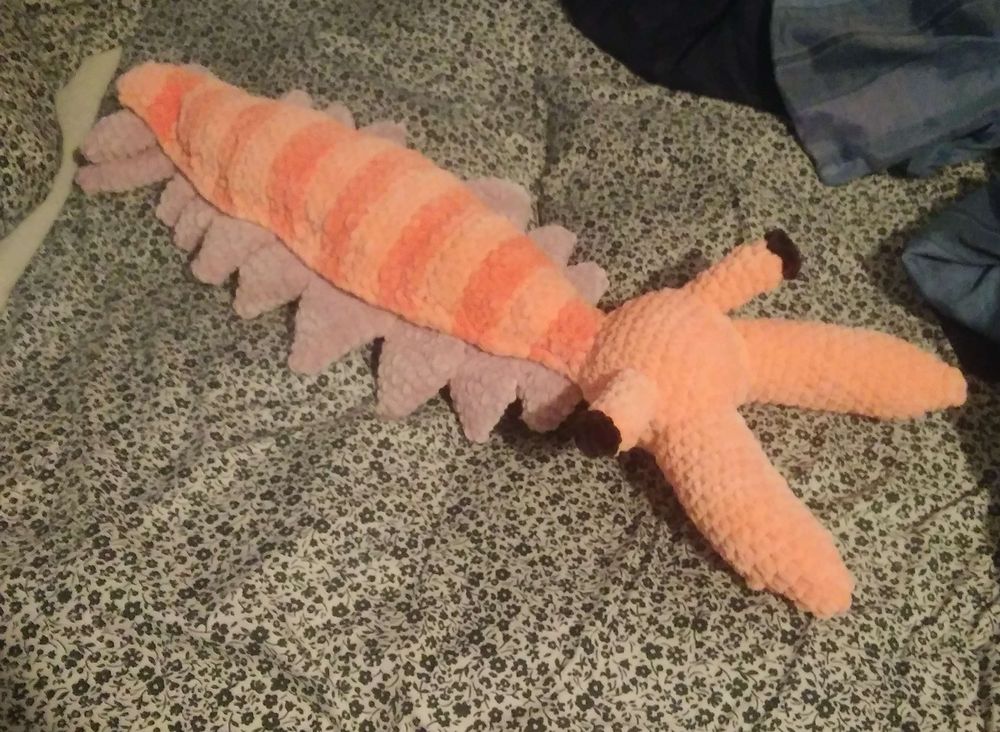 A photo of a pink and purple anomalocaris plush.
