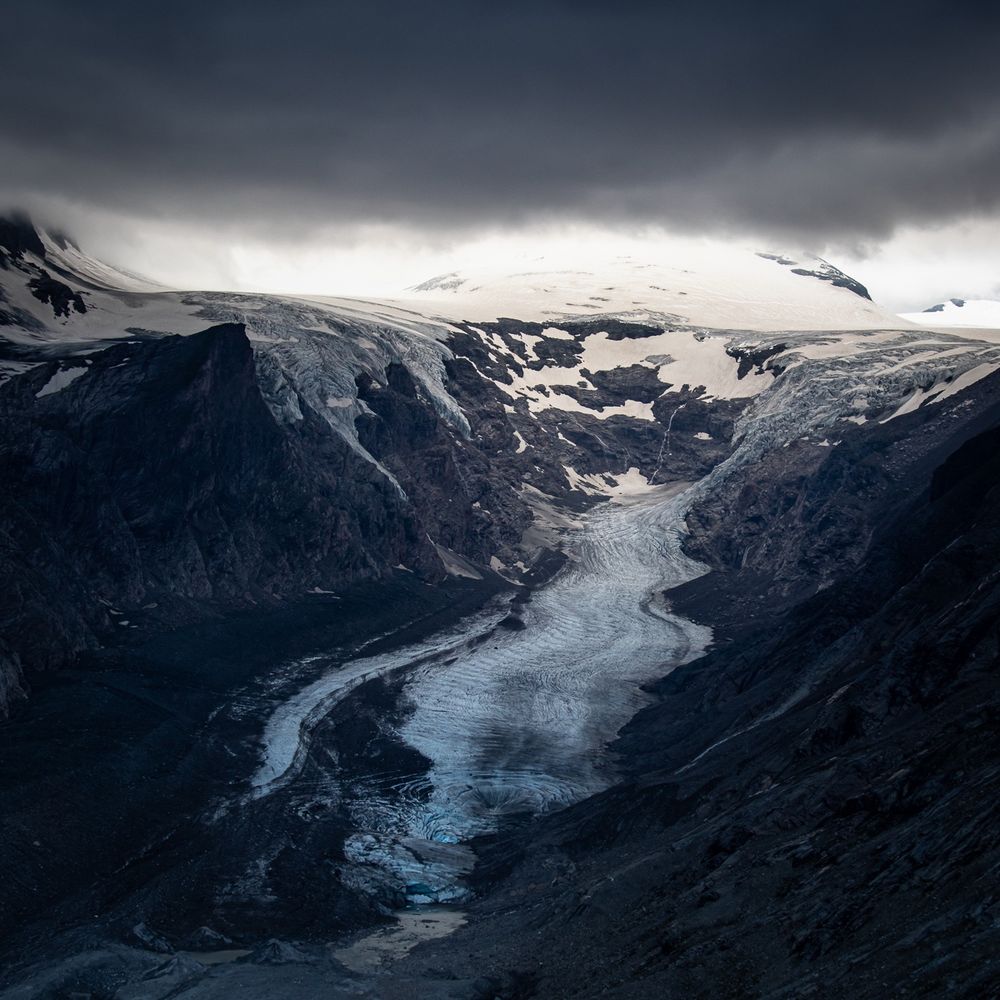 Der schmelzende Pasterzengletscher. Die Gletscherzunge ist größtenteils mit Schutt bedeckt, der Kontakt zu dem höher gelegenen Nährbereich ist fast abgerissen. 